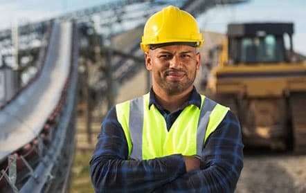 Worker in hard hat with heavy machinery