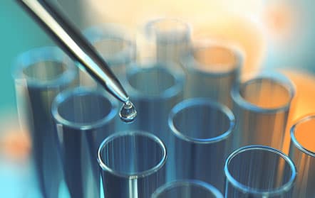 Dropper dispensing liquid into test tubes